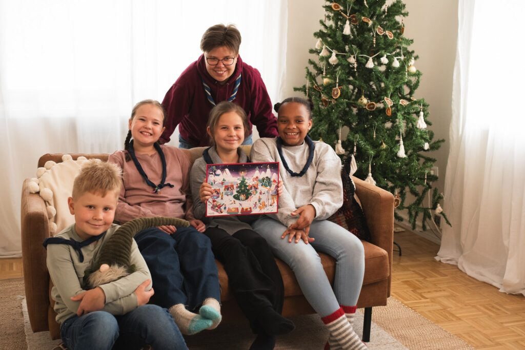 Viisi iloista partiolaista esittelee partiolaisten adventtikalenteria 2024.